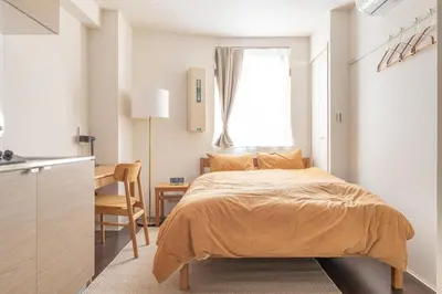 a small bedroom with a bed and a desk at Float Inn Asakusa in Tokyo