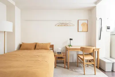 a bedroom with a bed and a desk and a table at Float Inn Asakusa in Tokyo