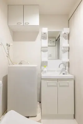 a white bathroom with a sink and a mirror at Float Inn Asakusa in Tokyo