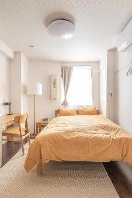 a bedroom with a bed and a desk and a window at Float Inn Asakusa in Tokyo