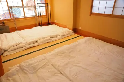two white beds in a room with two windows at \u53f0\u6771\u533a\u6d45\u8349\u3082\u3059\u3050,\u6700\u592710\u540d\u8cb8\u52073\u968e\u5efa\u3066,\u30b9\u30ab\u30a4\u30c4\u30ea\u30fc\u307e\u3067\u5f92\u6b6910\u5206,\u5168\u5ba4Chromecast\u5b8c\u5099,WonderfulStayTOKYO SKYTREE in Tokyo