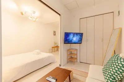 a bedroom with a bed and a tv on a wall at Mi-Ochiai Soluna White in Tokyo