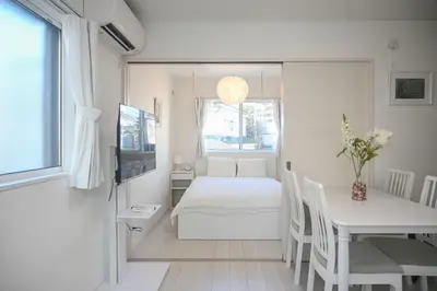 a bedroom with a bed and a table and a window at Mi-Ochiai Soluna White in Tokyo