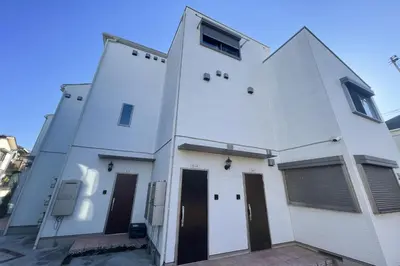 a white building with two doors and two windows at Mi-Ochiai Soluna White in Tokyo