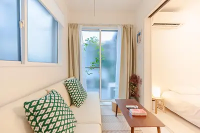 a living room with a couch and a bed and a window at Mi-Ochiai Soluna White in Tokyo