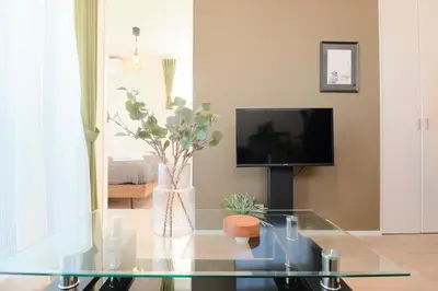 a living room with a glass table and a tv at EveryNet ShinjukuⅡ in Tokyo