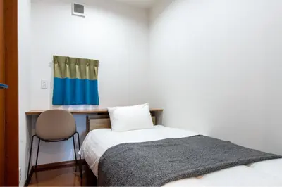 a bedroom with a bed and a desk with a chair at Residencial Voyan \u5357\u7802\u753a in Tokyo
