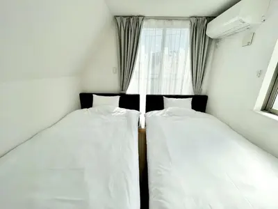 two beds in a small room with a window at Bisk Park Higashijujo - Vacation STAY 83637v in Tokyo