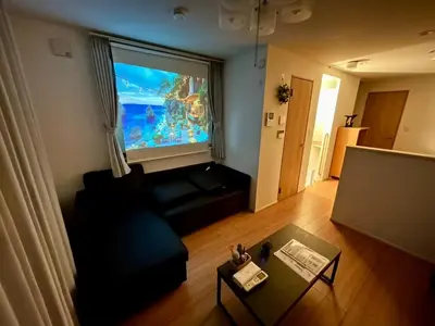 a living room with a large window and a black couch at Bisk Park Higashijujo - Vacation STAY 83637v in Tokyo