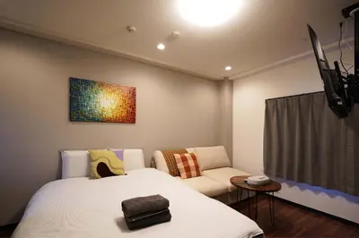a bedroom with a bed and a couch and a painting at Penthouse 1-bedroom flat in Hiroo Shibuya in Tokyo