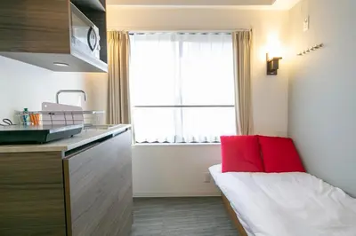 a small kitchen with a red pillow in a room at THE CONTRAIL Ebisu in Tokyo