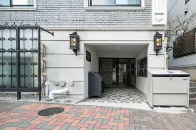 a white house with a black gate and a driveway at THE CONTRAIL Ebisu in Tokyo