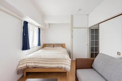 a small bedroom with a bed and a couch at G&R House 202　Shinjuku room in Tokyo