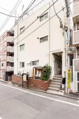 a white building on a city street with stairs at G&R House 202　Shinjuku room in Tokyo