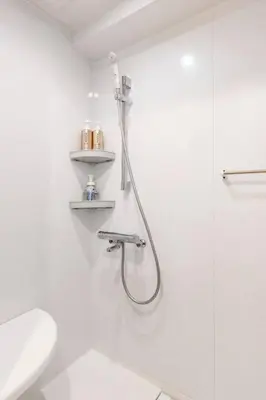 a white bathroom with a shower and a toilet at G&R House 202　Shinjuku room in Tokyo