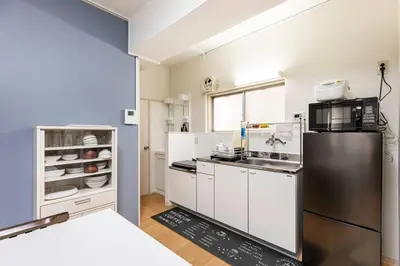 a kitchen with white cabinets and a refrigerator at G&R House 202　Shinjuku room in Tokyo