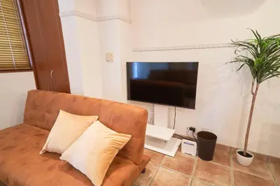a living room with a couch and a flat screen tv at FINOA Ikebukuro Sky Terrace Suite in Tokyo
