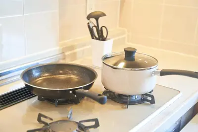 a pan on a stove with a pot on it at FINOA Ikebukuro Sky Terrace Suite in Tokyo