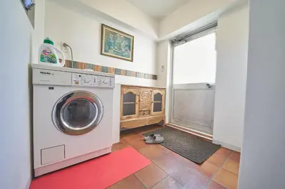 a laundry room with a washing machine and a red rug at FINOA Ikebukuro Sky Terrace Suite in Tokyo
