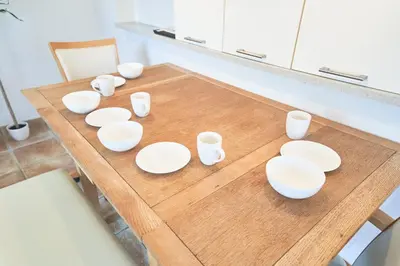 a wooden table with white bowls and cups on it at FINOA Ikebukuro Sky Terrace Suite in Tokyo