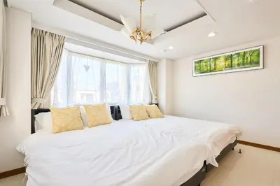 a bedroom with a large white bed with yellow pillows at L-Large 3Bedroom Luxury Condo, 140sqm Max 19 PPL, 7mins walk to station, Elevator,QuiteArea in Tokyo