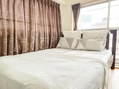 a bed with white sheets and pillows in front of a window at East Ikebukuro Living&Bed Sunshine City in Tokyo