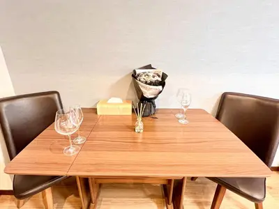 a wooden table with wine glasses and a vase on it at East Ikebukuro Living&Bed Sunshine City in Tokyo