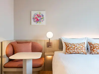 a bedroom with a bed and a chair and a table at Mitsui Garden Hotel Ginza Tsukiji in Tokyo