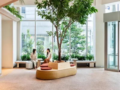 two women sitting around a tree in a building at Mitsui Garden Hotel Ginza Tsukiji in Tokyo
