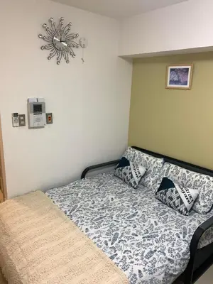 a bedroom with a bed with a comforter and pillows at \u8bda\u4fe1\u4e1c\u65b0\u5bbf in Tokyo