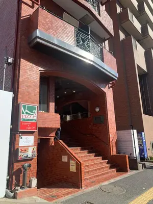 a brick building with stairs and a balcony on it at \u8bda\u4fe1\u4e1c\u65b0\u5bbf in Tokyo