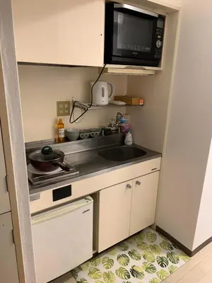a small kitchen with a sink and a microwave at \u8bda\u4fe1\u4e1c\u65b0\u5bbf in Tokyo