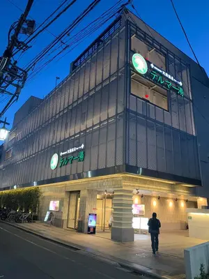 a man walking in front of a building at night at \u8bda\u4fe1\u4e1c\u65b0\u5bbf in Tokyo