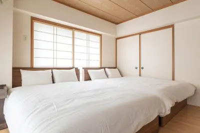 a large white bed in a room with windows at A Marvelous Blend of Tradition and Modernity, Independent 1st-floor Suite, Accommodates Up to 10 Guests! in Tokyo