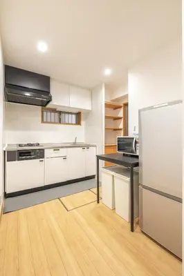 a kitchen with white cabinets and a black counter top at A Marvelous Blend of Tradition and Modernity, Independent 1st-floor Suite, Accommodates Up to 10 Guests! in Tokyo