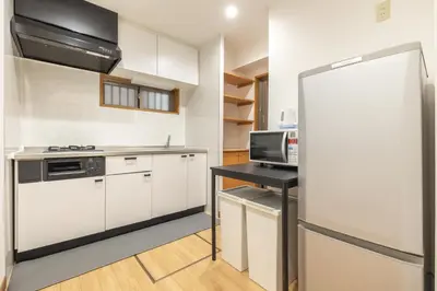 a kitchen with white cabinets and a refrigerator at A Marvelous Blend of Tradition and Modernity, Independent 1st-floor Suite, Accommodates Up to 10 Guests! in Tokyo