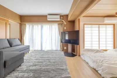 a living room with a couch and a flat screen tv at A Marvelous Blend of Tradition and Modernity, Independent 1st-floor Suite, Accommodates Up to 10 Guests! in Tokyo