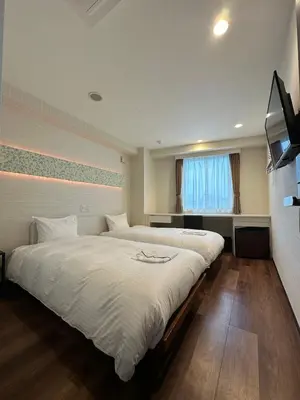 a bedroom with two large beds and a window at ELE Hotel \u6771\u65e5\u672c\u6a4b in Tokyo