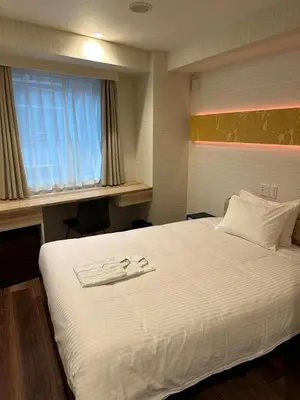 a bedroom with a bed with two towels on it at ELE Hotel \u6771\u65e5\u672c\u6a4b in Tokyo