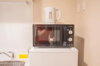 a microwave with a coffee pot on top of it at The most comfortable and best choice for accommodation in Yoyogi EoW6 in Tokyo