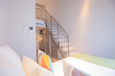 a room with a staircase with a bed and a stair case at The most comfortable and best choice for accommodation in Yoyogi SoSI in Tokyo