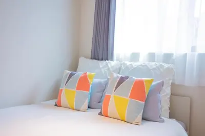 a bed with four pillows on it with a window at The most comfortable and best choice for accommodation in Yoyogi SoSI in Tokyo