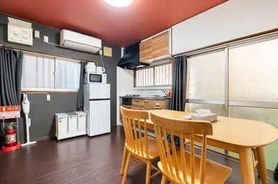 a kitchen with a table and chairs and a refrigerator at \u30a2\u30f3\u30c9\u30b9\u30c6\u30a4\u897f\u5c0f\u5ca91\u4e01\u76ee in Tokyo