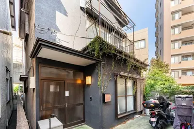 a building with a door and a motorcycle parked next to it at \u30a2\u30f3\u30c9\u30b9\u30c6\u30a4\u897f\u5c0f\u5ca91\u4e01\u76ee in Tokyo