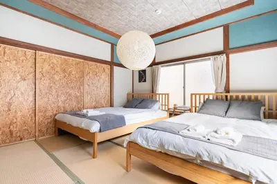 a bedroom with two beds and a large window at \u30a2\u30f3\u30c9\u30b9\u30c6\u30a4\u897f\u5c0f\u5ca91\u4e01\u76ee in Tokyo