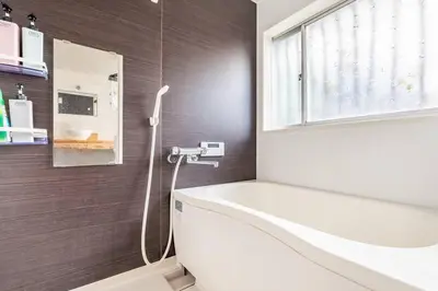 a bathroom with a white tub and a sink at \u30a2\u30f3\u30c9\u30b9\u30c6\u30a4\u897f\u5c0f\u5ca91\u4e01\u76ee in Tokyo