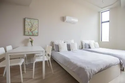a white bedroom with a bed and a table at The most comfortable and best choice for accommodation in Yoyogi SioY5 in Tokyo