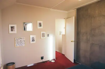 a hallway with a white wall with pictures on it at lobby, tateishi - Sauna & Stay in Tokyo