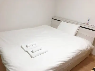 a white bed with two white towels on it at \u30a2\u30f3\u30c9\u30b9\u30c6\u30a4\u5357\u9577\u5d0e5\u4e01\u76ee in Tokyo