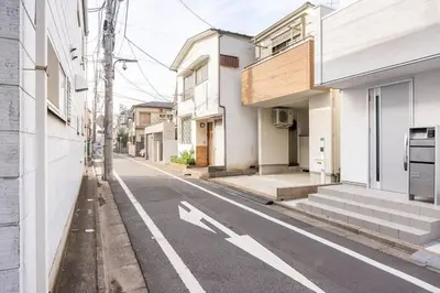an empty street with white buildings and an arrow on the road at \u30a2\u30f3\u30c9\u30b9\u30c6\u30a4\u5357\u9577\u5d0e5\u4e01\u76ee in Tokyo